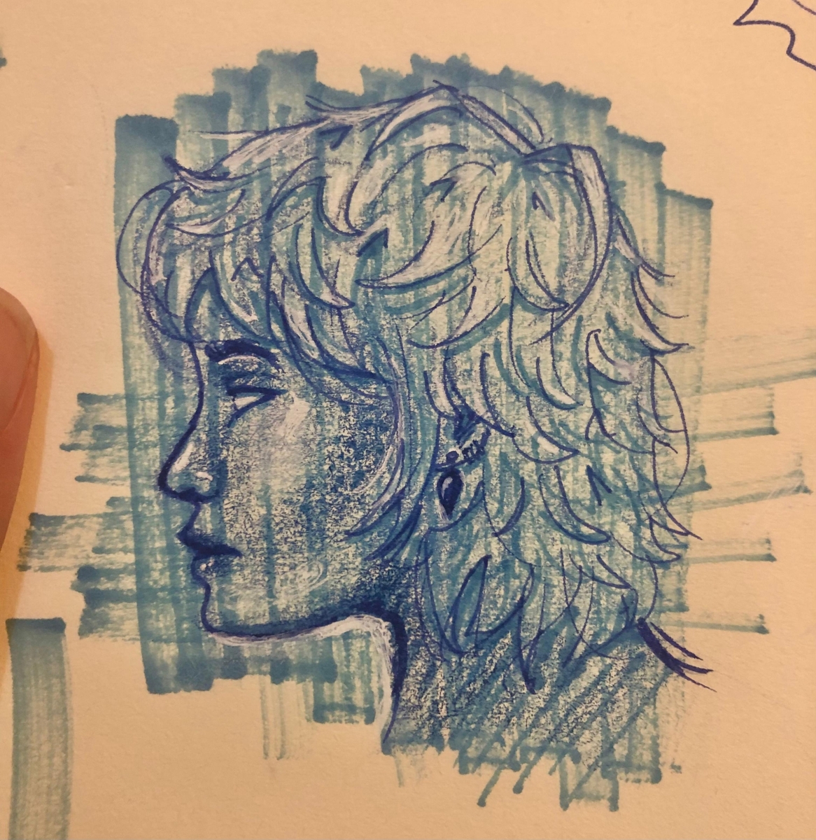 A drawing of a woman's side profile, with blue markers and colour pencils. The woman has fluffy hair, multiple ear piercings and dark lips. Her one visible eye is blank, with no pupils or irises, and her expression is neutral.